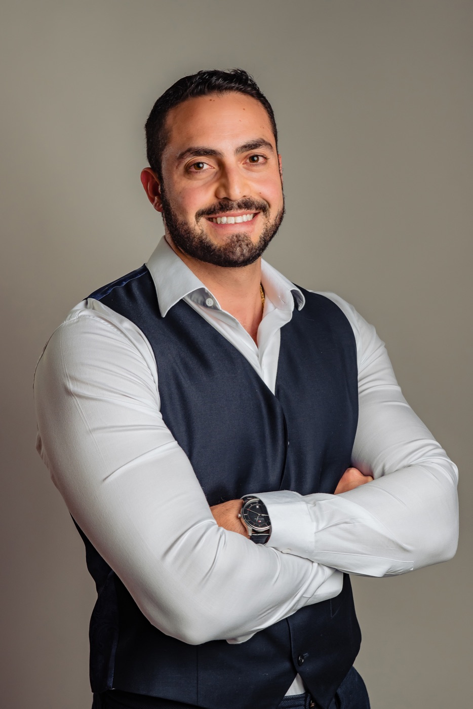 Retrato do Dr. Yussef Alli sorrindo, de braços cruzados